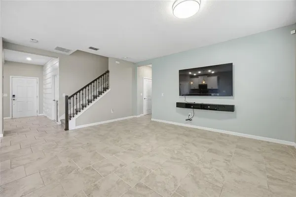 a view of an empty room with furniture and a flat screen tv
