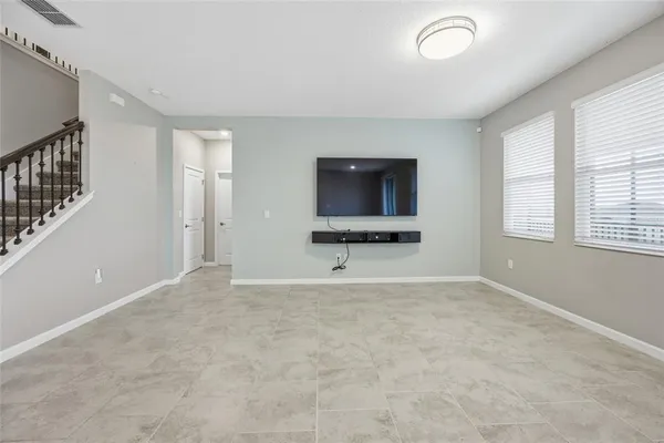 a view of an empty room with a window and a flat screen tv