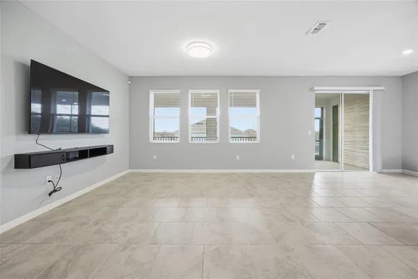 a view of an empty room with glass door and windows