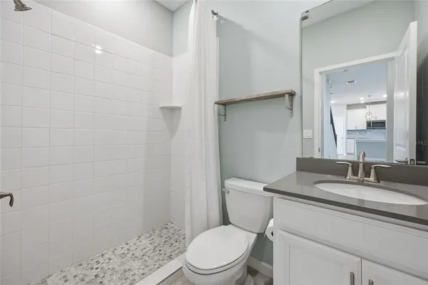 a bathroom with a sink a toilet and shower