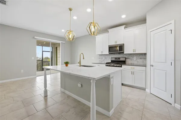 a kitchen with kitchen island granite countertop stove top oven and cabinets