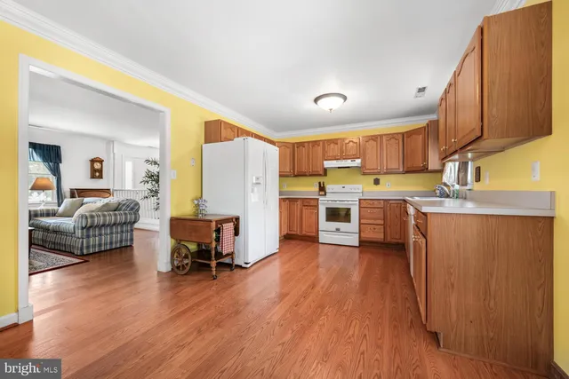 a living room with stainless steel appliances kitchen island granite countertop wooden floors and a view of living room