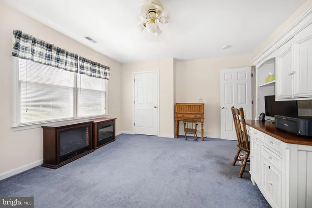 a livingroom with kitchen island hardwood floor and a flat screen tv