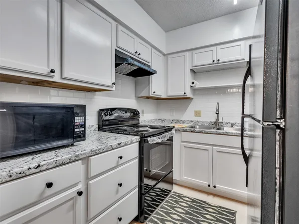 a kitchen with stainless steel appliances granite countertop a stove and a microwave