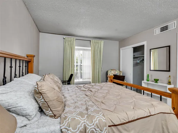 a bedroom with a bed window and dresser