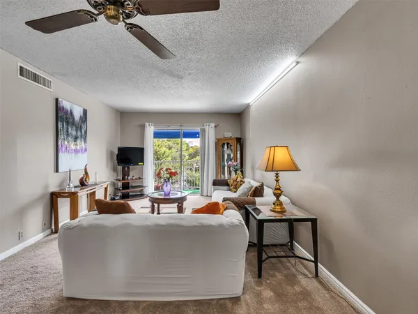 a living room with furniture a window and a flat screen tv