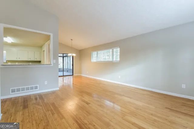 a view of a room with wooden floor and a window