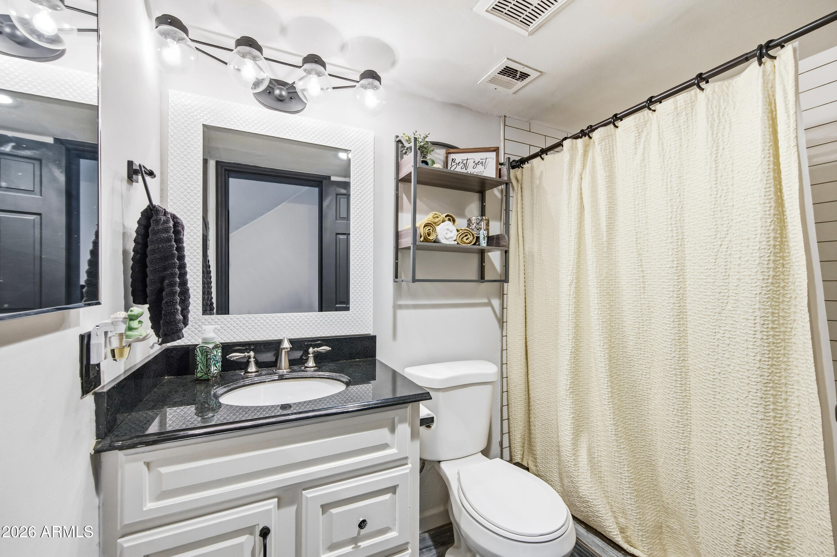 1702 East Ocotillo Road, Unit 1 Phoenix, AZ 85016 - Photo 14 of 27 a bathroom with a toilet a sink and a mirror