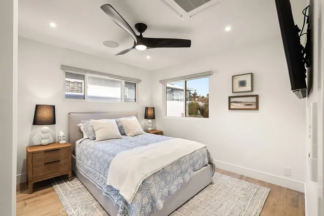 a bedroom with a bed a couch and a flat screen tv