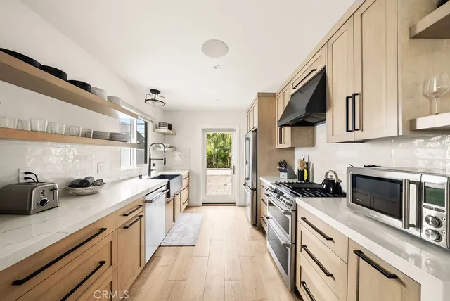a kitchen with stainless steel appliances a sink stove and cabinets