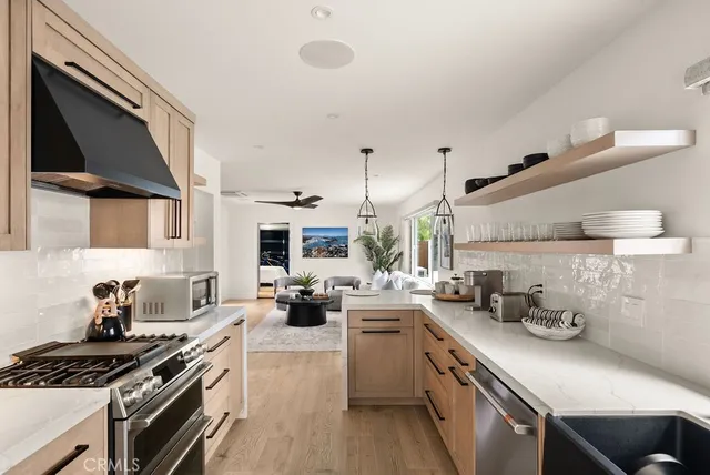 a kitchen with stainless steel appliances a sink a stove and cabinets