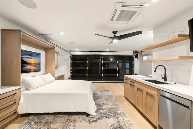 a large white kitchen with a sink and dishwasher with a fireplace