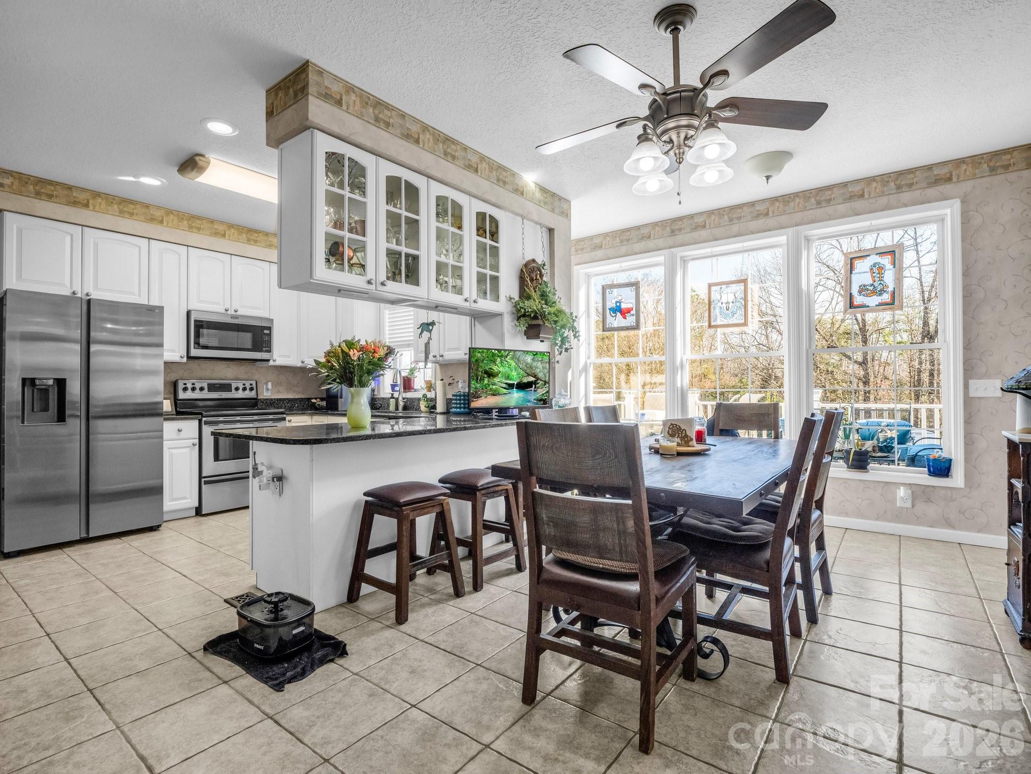 532 Harvey Logan Road Bostic, NC 28018 - Photo 28 of 48 a kitchen with stainless steel appliances kitchen island granite countertop a dining table chairs and a refrigerator