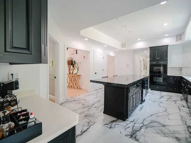 a kitchen with stainless steel appliances kitchen island granite countertop a sink and cabinets