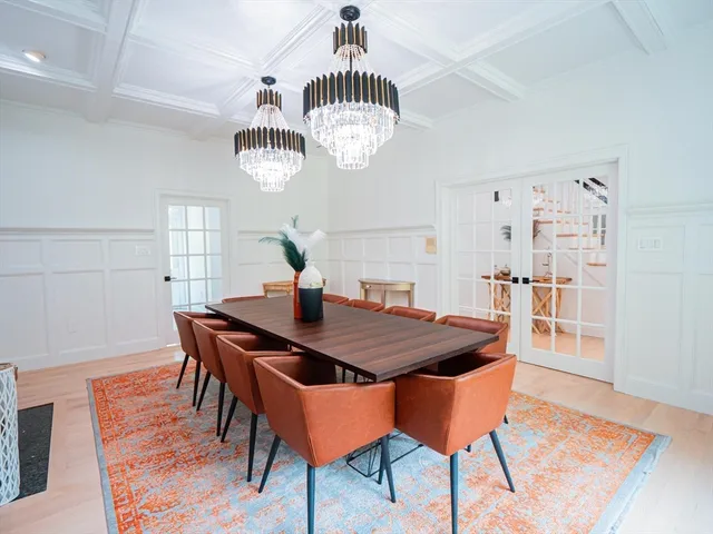 a dining room with furniture a chandelier and wooden floor