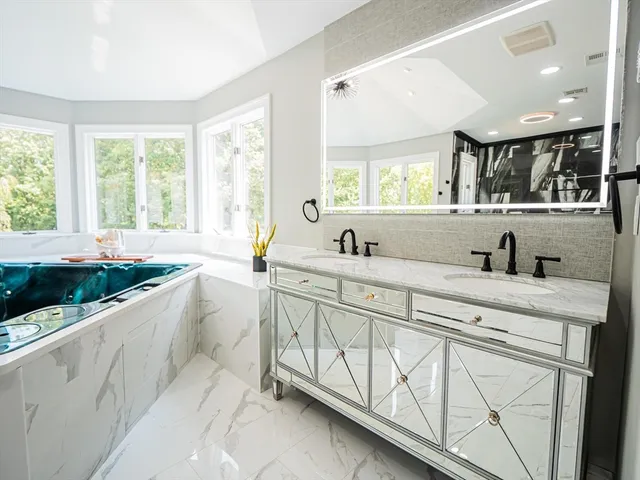 a spacious bathroom with a double vanity sink a mirror and a bathtub