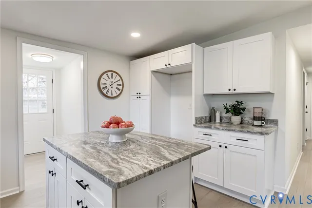 a kitchen with white cabinets and sink