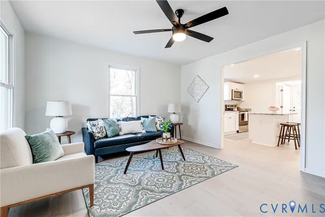 a living room with furniture and a view of kitchen