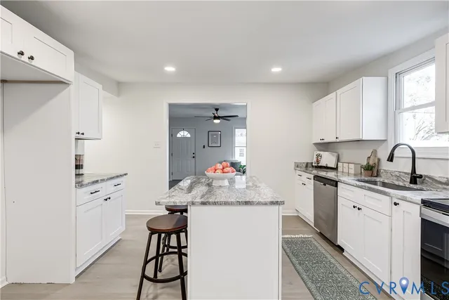 a kitchen with white cabinets and chairs