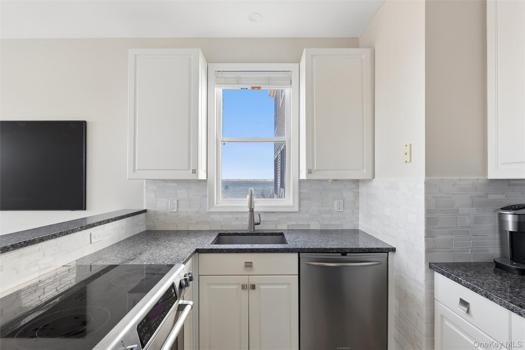 580 Dune Road, Unit 3 Westhampton Beach, NY 11978 - Photo 12 of 36 a kitchen with granite countertop a sink stove and cabinets