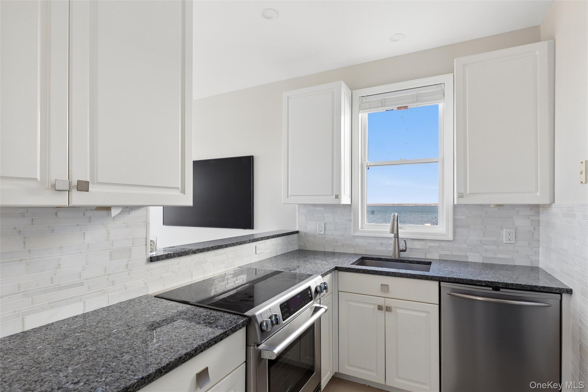 580 Dune Road, Unit 3 Westhampton Beach, NY 11978 - Photo 13 of 36 a kitchen with granite countertop a sink stove and cabinets