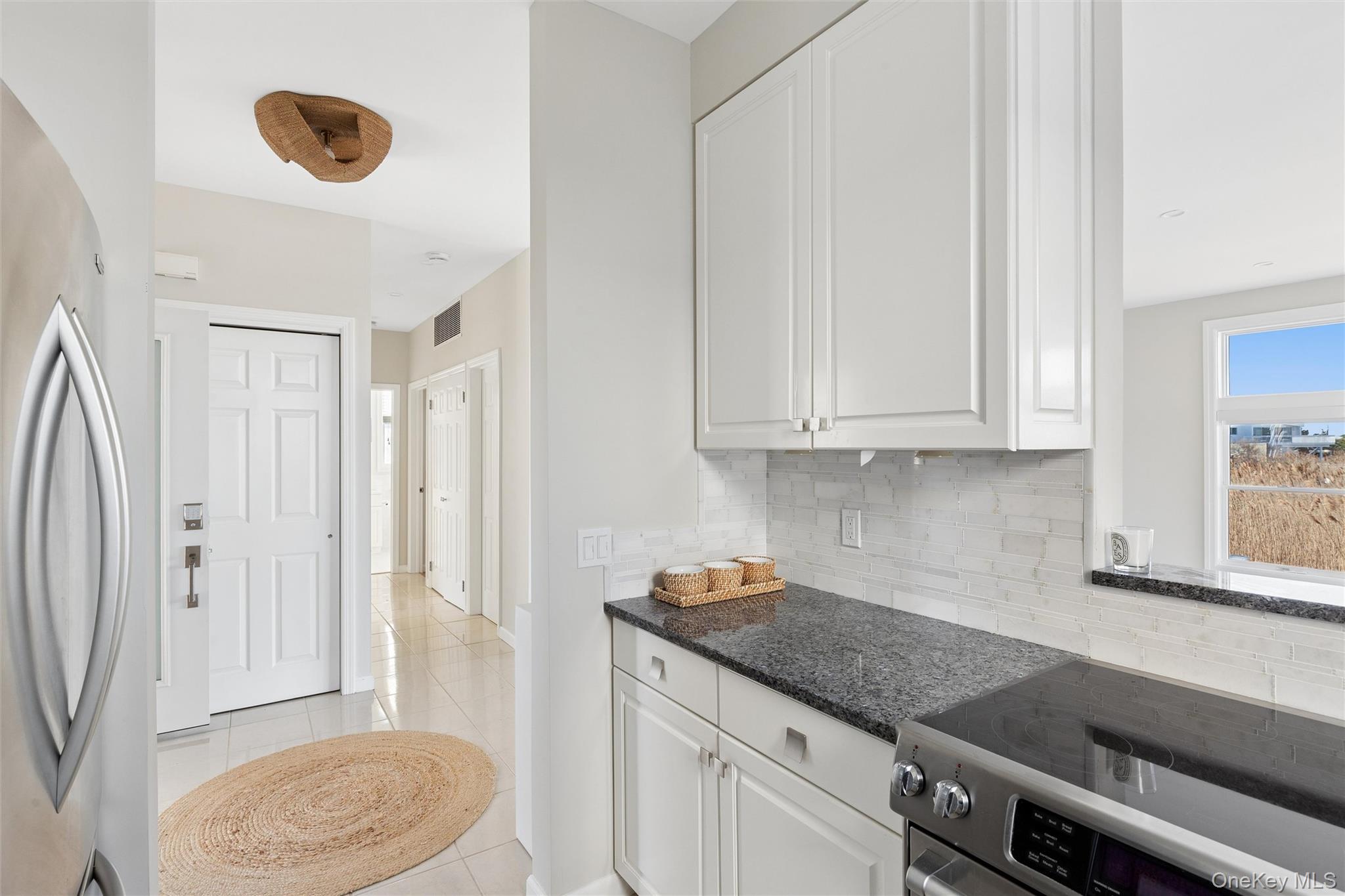 580 Dune Road, Unit 3 Westhampton Beach, NY 11978 - Photo 14 of 36 a kitchen with stainless steel appliances granite countertop a sink and a white cabinets