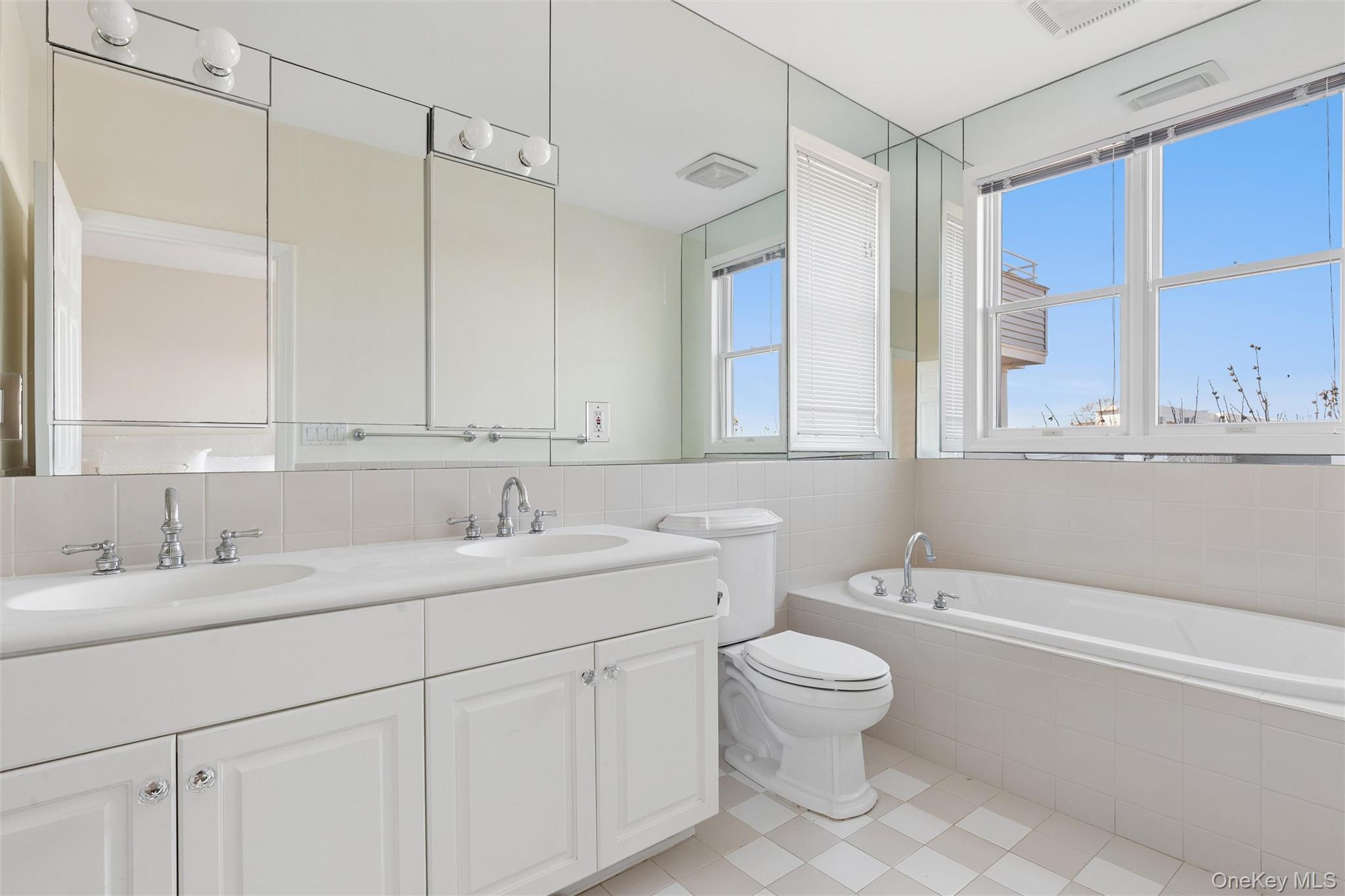 580 Dune Road, Unit 3 Westhampton Beach, NY 11978 - Photo 19 of 36 a bathroom with a granite countertop sink a toilet and a bathtub