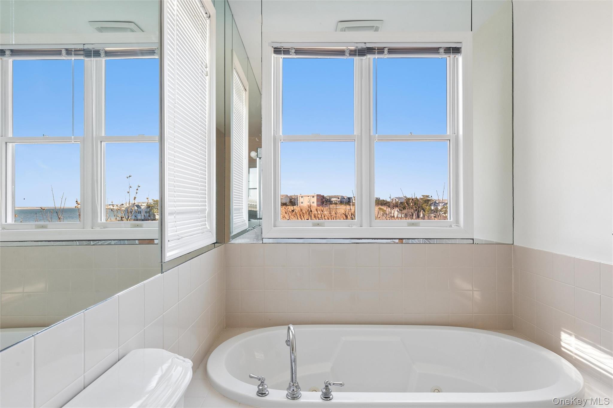 580 Dune Road, Unit 3 Westhampton Beach, NY 11978 - Photo 20 of 36 a bathroom with a bathtub and window