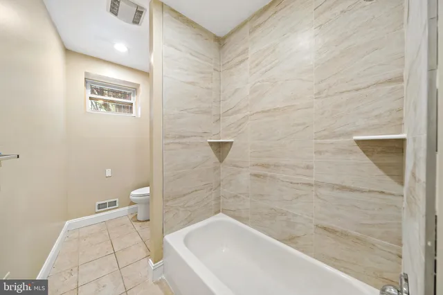 a bathroom with a bathtub and toilet