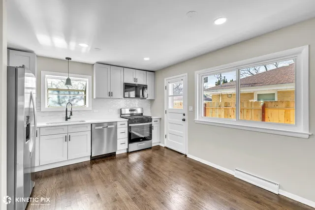 a kitchen with stainless steel appliances granite countertop a stove a sink and a refrigerator