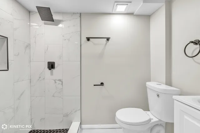 a white toilet sitting next to a shower