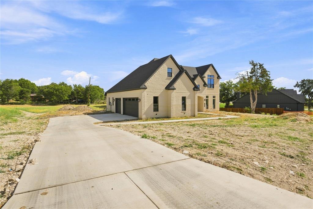 3820 Jack's Loop Midlothian, TX 76065 - Photo 3 of 40 Brick exterior with a dark shingle roof, attached two-car garage, and concrete driveway