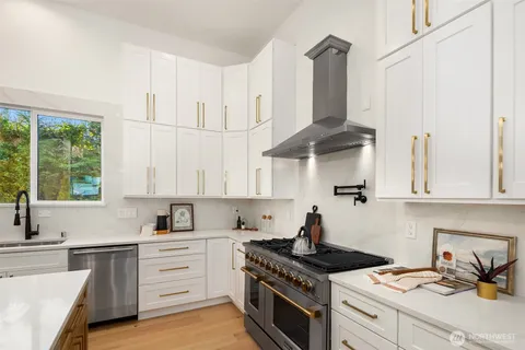 a kitchen with stainless steel appliances granite countertop a sink stove and cabinets