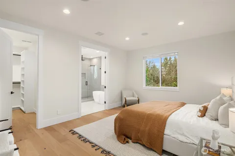 a bedroom with a bed and wooden floor