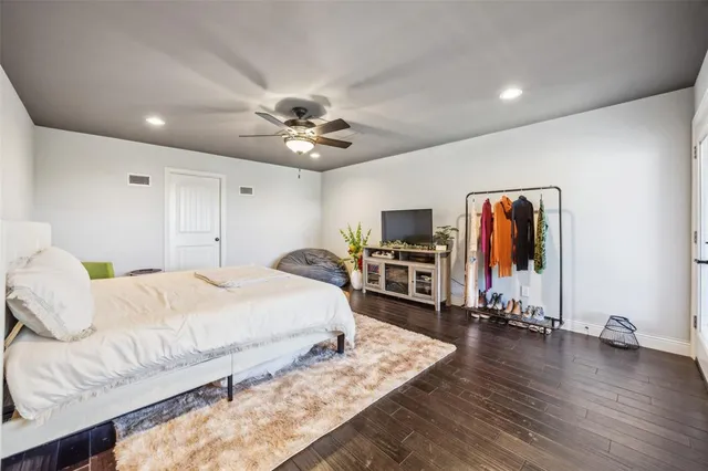 a spacious bedroom with a bed and a flat screen tv