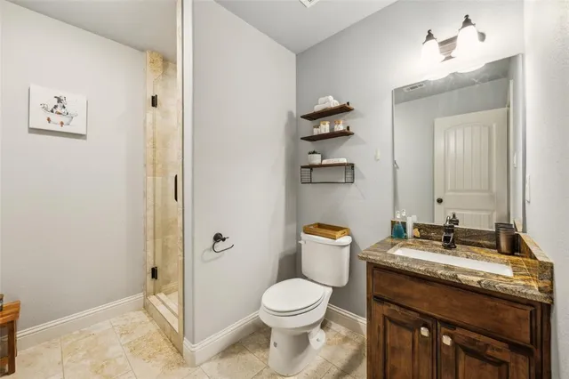 a bathroom with a granite countertop toilet sink and mirror