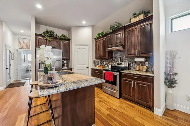 a kitchen with granite countertop a sink stainless steel appliances and cabinets