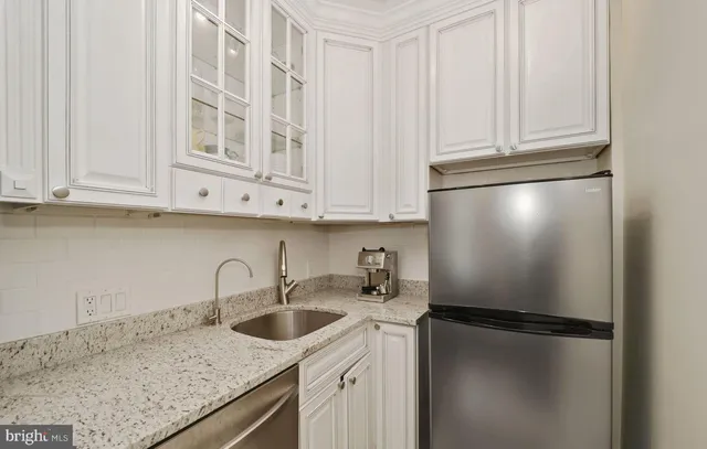 a kitchen with stainless steel appliances granite countertop a sink and a refrigerator