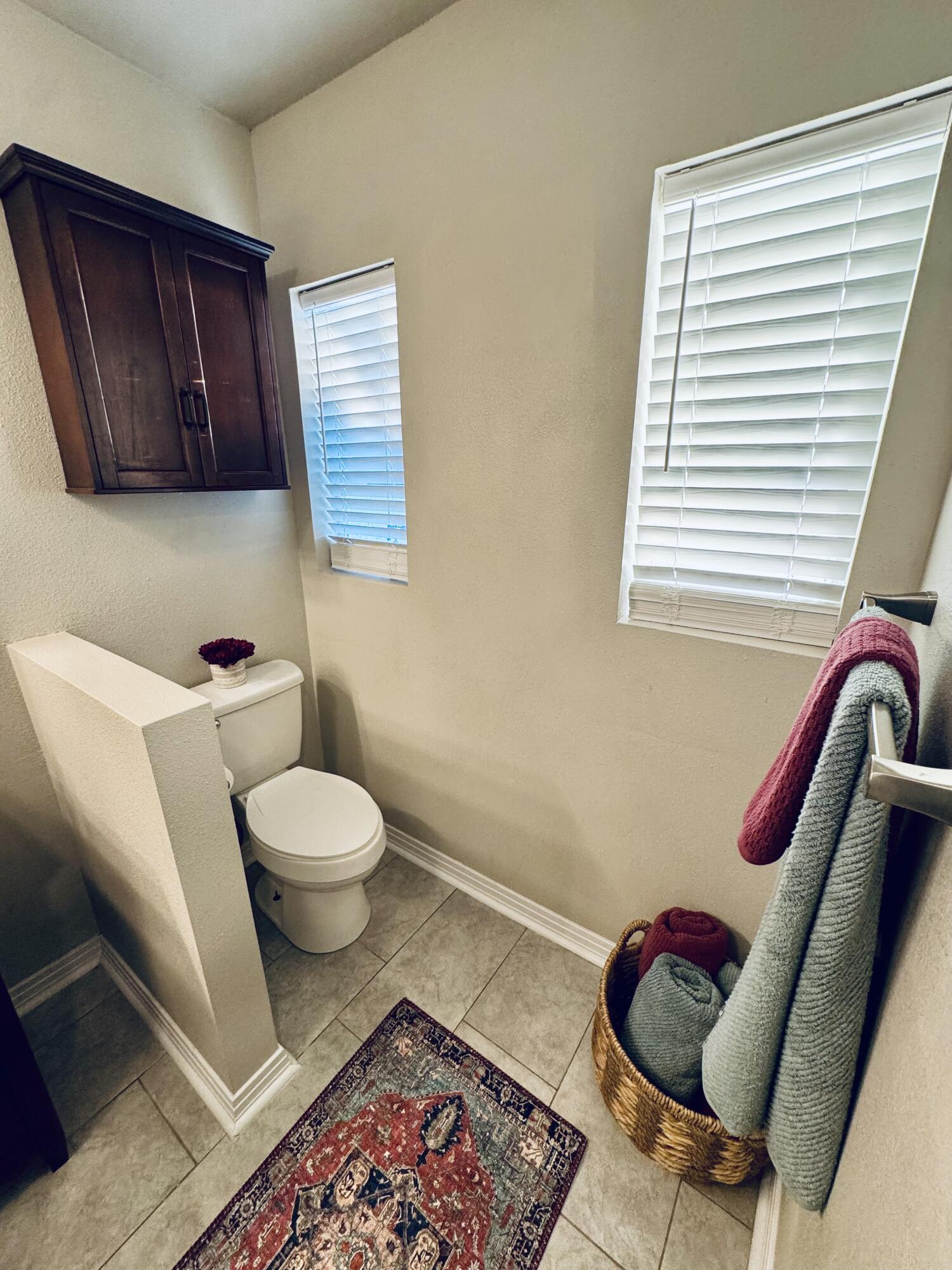 2509 30th Street Lubbock, TX 79410 - Photo 14 of 26 a bathroom with a toilet a sink and a window