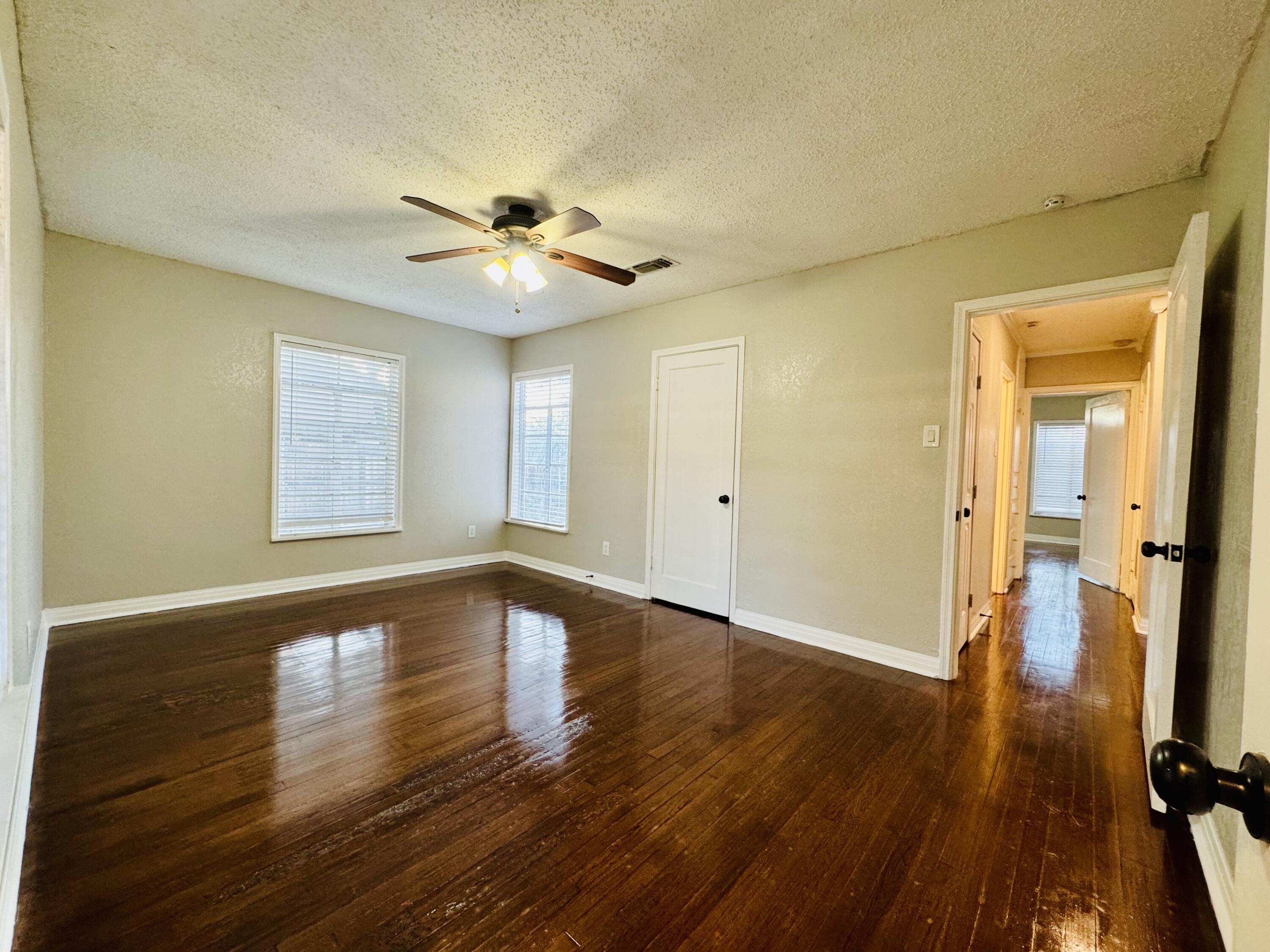 2509 30th Street Lubbock, TX 79410 - Photo 15 of 26 a view of an empty room with wooden floor and a window