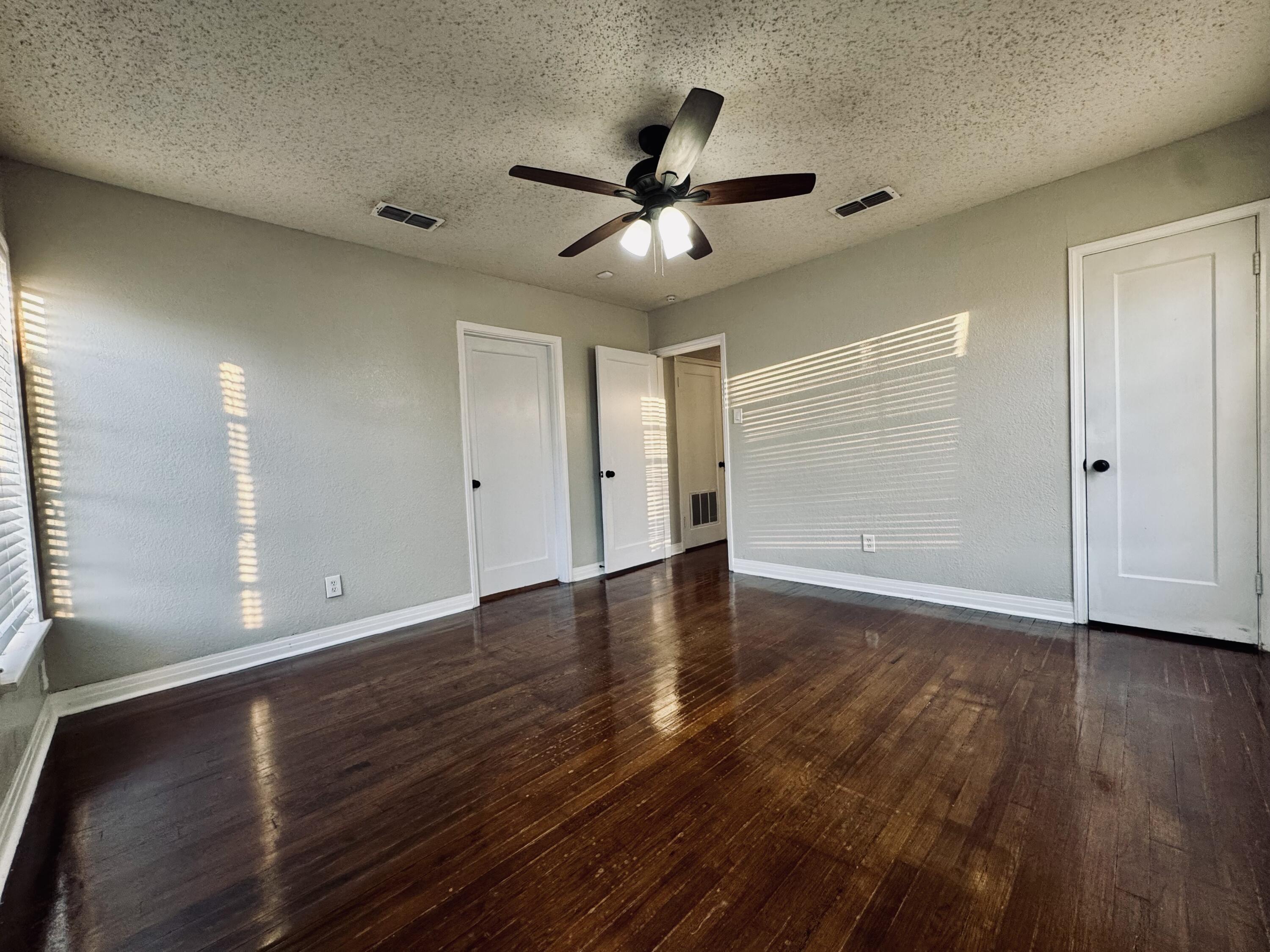 2509 30th Street Lubbock, TX 79410 - Photo 18 of 26 a view of an empty room with wooden floor and a ceiling fan