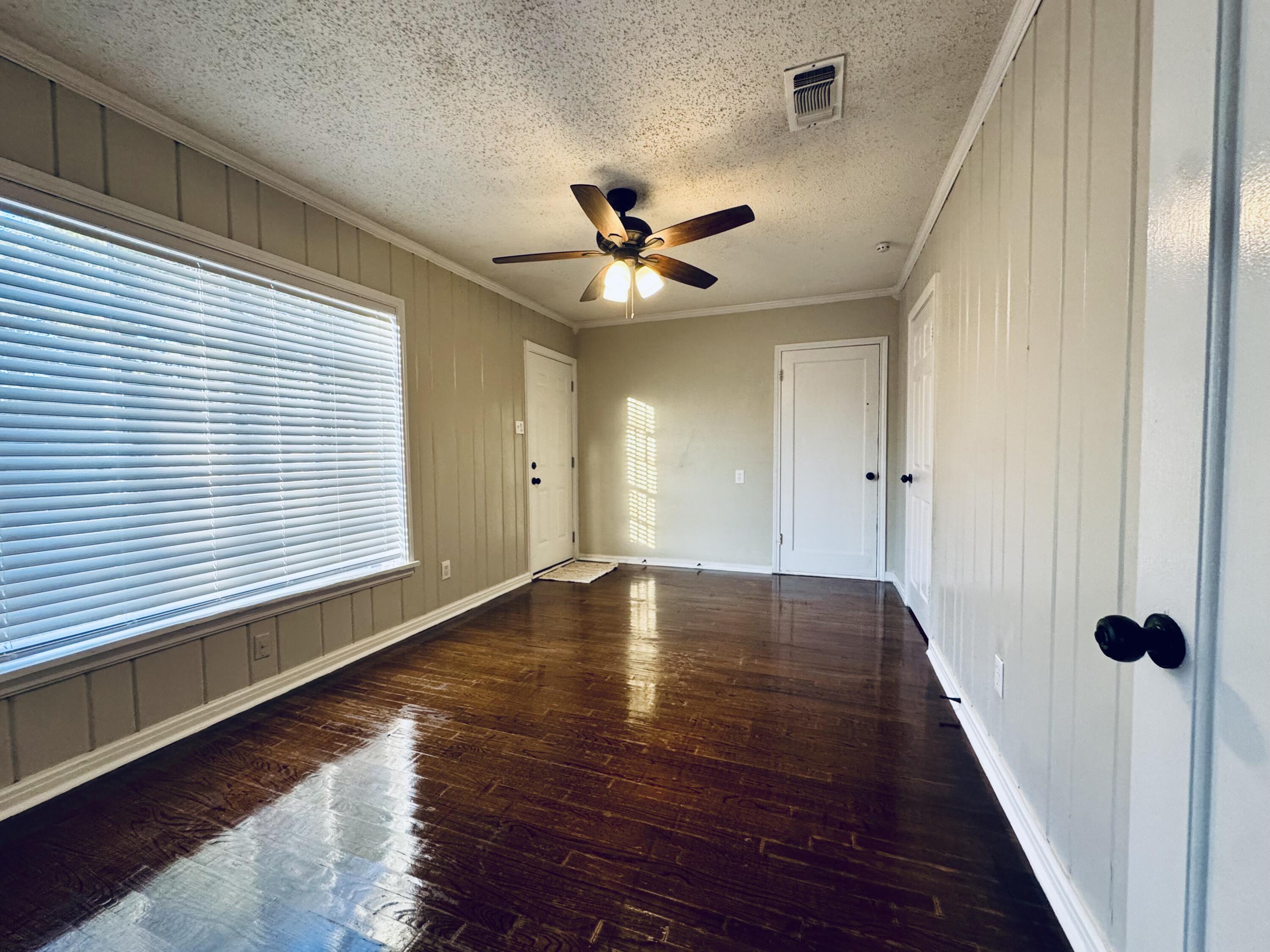2509 30th Street Lubbock, TX 79410 - Photo 19 of 26 a view of an empty room with a window and wooden floor