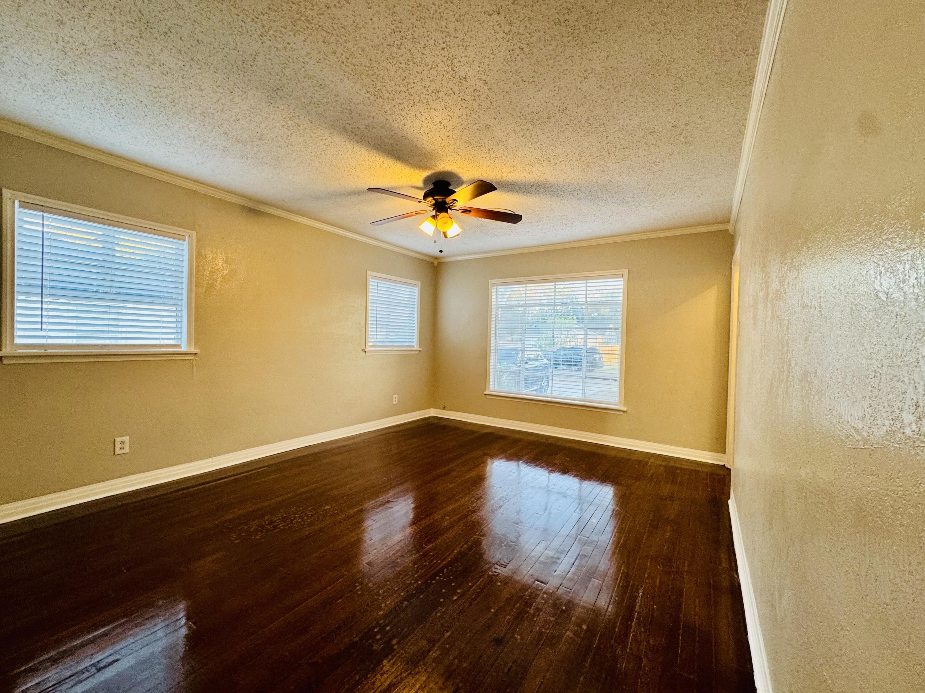 2509 30th Street Lubbock, TX 79410 - Photo 20 of 31 a view of an empty room with wooden floor and a window
