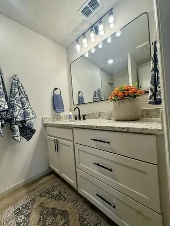 a bathroom with a granite countertop sink a mirror and vanity