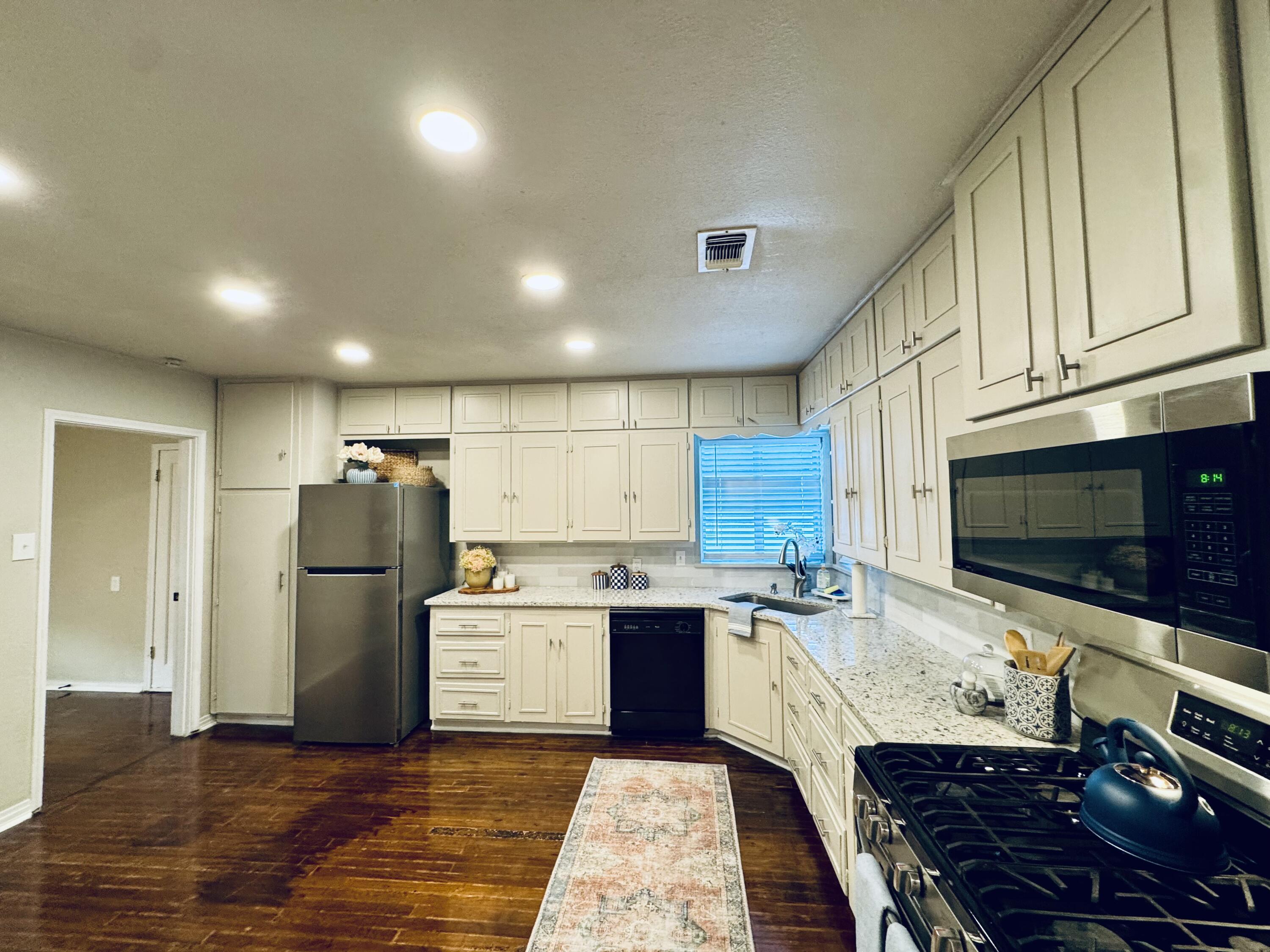 2509 30th Street Lubbock, TX 79410 - Photo 3 of 26 a kitchen with refrigerator and cabinets