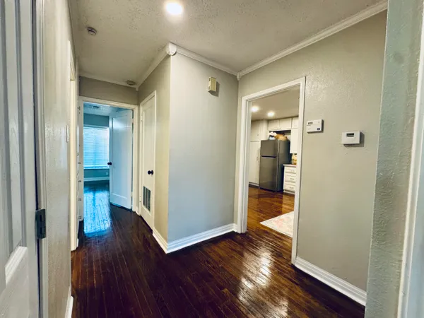 a view of a hallway with wooden floor