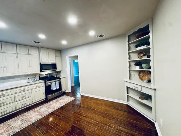 a kitchen with granite countertop white cabinets and stainless steel appliances
