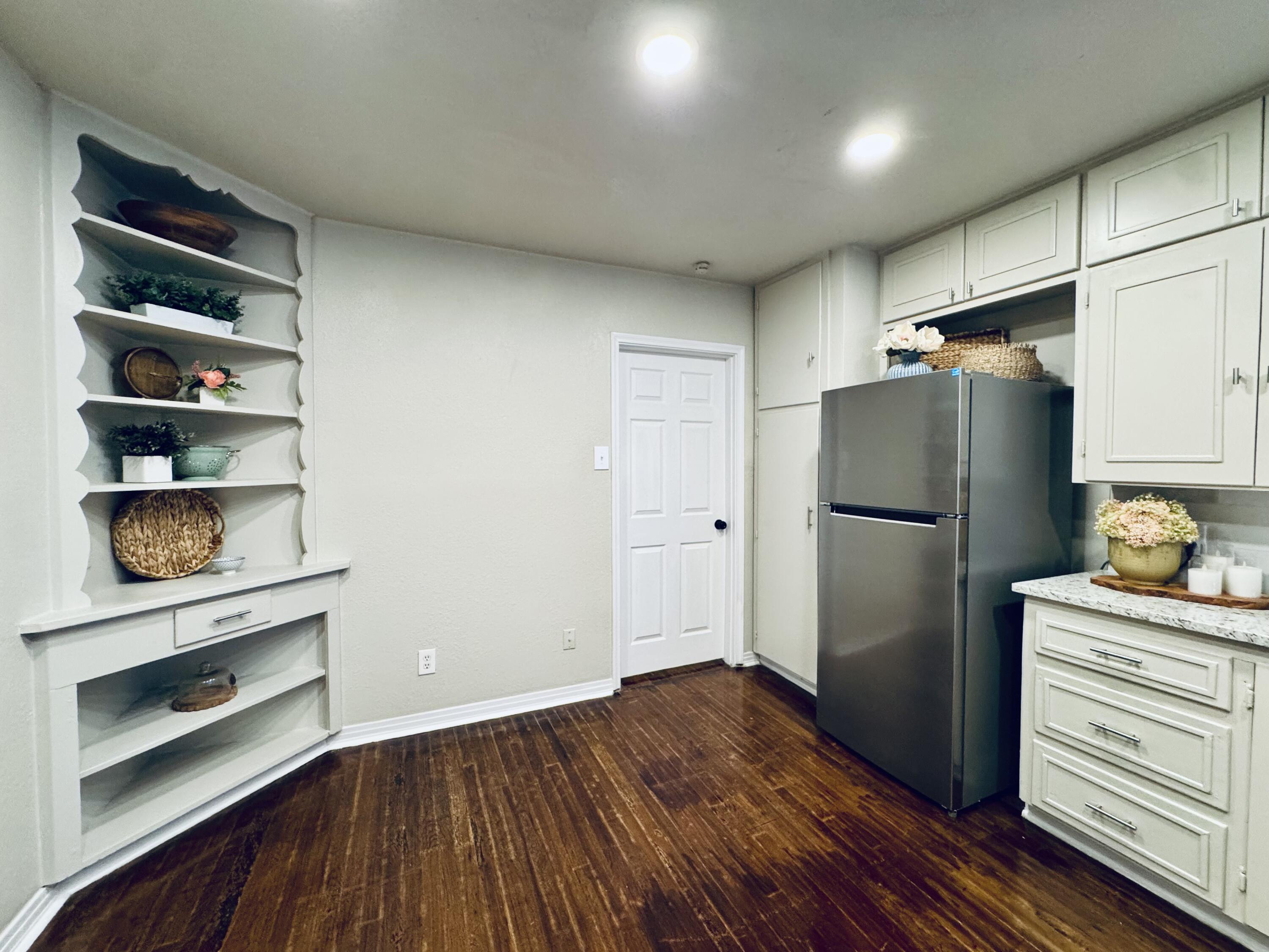 2509 30th Street Lubbock, TX 79410 - Photo 6 of 26 a kitchen with a refrigerator and wooden floor