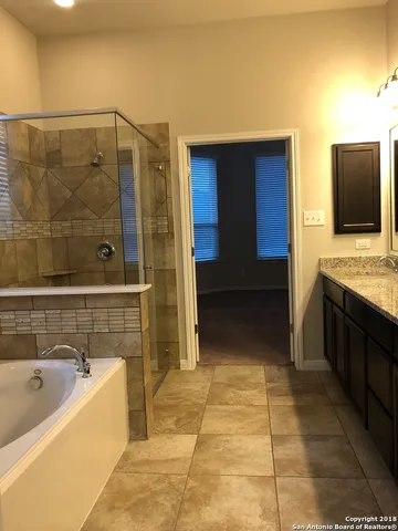 a bathroom with a tub a sink and a mirror