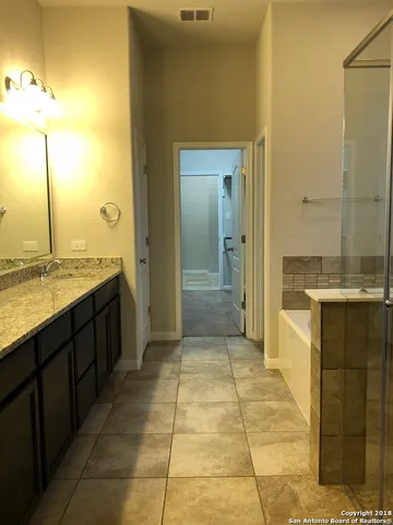a bathroom with a granite countertop sink and a mirror